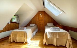シムリスハムンにあるTobishirdgårdのベッド2台と窓が備わる屋根裏部屋です。