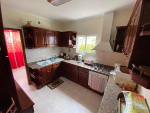 a kitchen with wooden cabinets and a sink at Maria's House - São Jorge in Santana