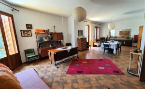a living room with a table and a dining room at Appartamento spazioso e fresco in punto strategico. in Castellammare del Golfo