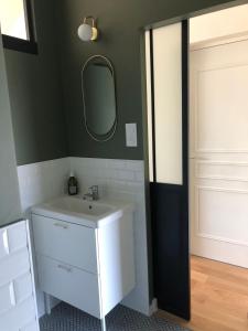 a bathroom with a white sink and a mirror at La Sodilie proche centre ville au calme Parking public gratuit in Nantes +13 photos
