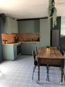 uma cozinha com uma mesa de madeira e cadeiras num quarto em "La Sodilie" charmante maison de ville em Nantes