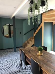 a dining room with a wooden table and a mirror at La Sodilie proche centre ville au calme Parking public gratuit in Nantes