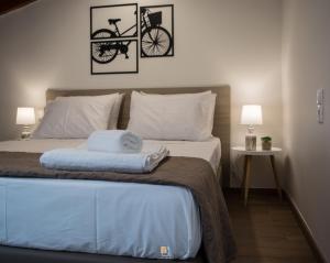 1 dormitorio con 1 cama con una bicicleta en la pared en Uni Island - Old Town Suites en Heraclión