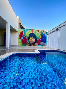 a swimming pool with a painting on the side of a building at Hostel Flor de Carajás in Parauapebas