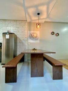 a table and bench in a room with a refrigerator at Hostel Flor de Carajás in Parauapebas