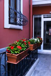 una fila de cajas de flores en un balcón en La Villa bed & breakfast, en Milán