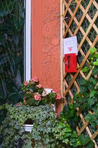 un buzón rojo al lado de un edificio con flores en La Villa bed & breakfast, en Milán