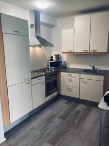 a kitchen with white cabinets and a stove top oven at Downtown North Apartment in Akureyri