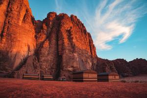 two buildings in front of a rocky mountain at Bedouin Nights Camp in Wadi Rum