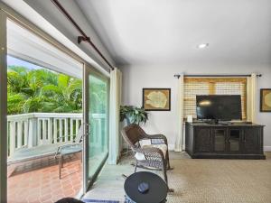 a living room with a tv and a sliding glass door at Spacious Updated Condo Just 2 Blocks to Siesta Key Beach in Siesta Key