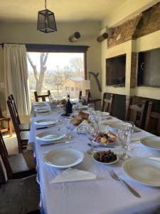 a long table with white plates and wine glasses at las brisas casas de campo un lugar para soñar in San Antonio de Arredondo