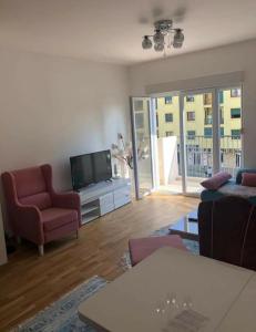 a living room with a couch and a tv at KENZA jednosobni stanovi in Podgorica +16 photos