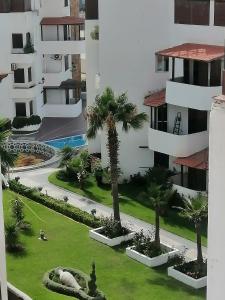 een luchtzicht op een gebouw met palmbomen en een tuin bij DUNES DE MARTIL in Martil