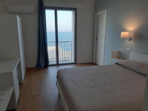 a bedroom with a bed and a view of the ocean at Azzurromare in San Vito Chietino