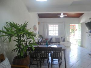 a dining room with a table and chairs with a plant at VIVA BUZIOS no Condominio Aqua Marina casa13 in Búzios