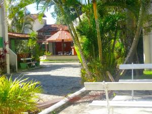 a white bench in front of a house with palm trees at VIVA BUZIOS no Condominio Aqua Marina casa13 in Búzios