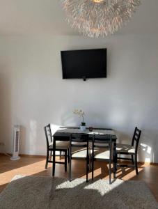 a dining room with a table and chairs and a television at Hubert in Berlin