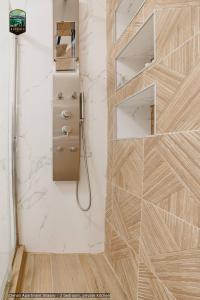 a bathroom with a shower with a wooden wall at Sierra - Northstar Apartments in Braşov