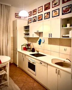 a kitchen with white cabinets and a sink at Kwatera Prywatna Marini in Sopot