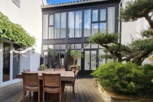 a dining room with a wooden table and chairs at La Martinoise Patio in Saint-Martin-de-Ré