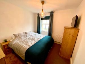 a bedroom with a bed and a television in it at The Old Post Office - Giggleswick in Giggleswick