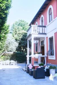 Edificio rojo y blanco con sillas y balcón en La Villa bed & breakfast, en Milán