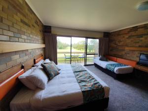 a hotel room with two beds and a balcony at Shepparton Golf Motel in Shepparton