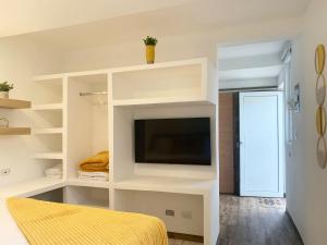 a bedroom with a tv in a white shelf at Silver Sun Apartment in Guatemala