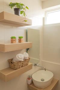 baño con aseo y estanterías con plantas en Silver Sun Apartment, en Guatemala