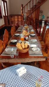 Pukyo Bed and breakfast Belgian lao في Ban Nangoy: طاولة خشبية طويلة عليها صحون طعام