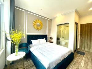 a bedroom with a large bed and a vase of flowers at Phuong Vy Luxury Hotel in Da Lat