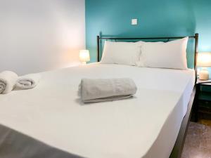 - un grand lit blanc avec une serviette dans l'établissement Nyx Apartments, à Ancient Epidavros