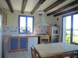 a kitchen with a wooden table and a dining room at Holiday Home near Goëlo Coast & Beaches in Plourivo