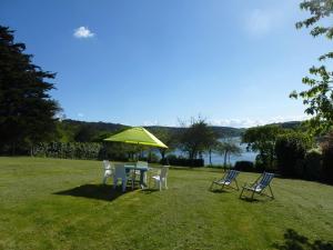 a table and chairs with a green umbrella at Holiday Home near Goëlo Coast & Beaches in Plourivo