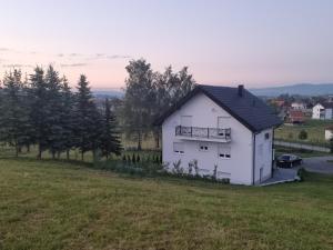 a white house on top of a grass field at Uvac lake "FF" in Sjenica