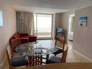 a living room with a glass table and a couch at San Alfonso 507 in Algarrobo