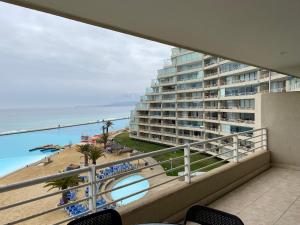 a balcony with a view of a beach and a building at San Alfonso 507 in Algarrobo