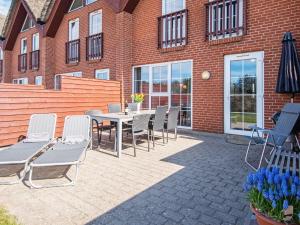 a patio with a table and chairs in front of a brick building at Holiday home Rømø CXXV in Kongsmark