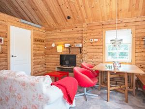 a log cabin living room with a table and red chairs at Holiday home Hovborg VII in Hovborg