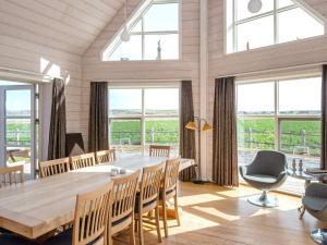 comedor con mesa, sillas y ventanas en Four-Bedroom Holiday home in Harboøre 8, en Harboør