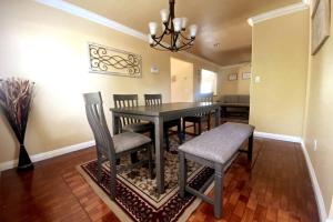 a dining room with a black table and chairs at HUGE GORGEOUS UPGRADED HOME IN THE CENTER OF SOCAL in Loma Linda