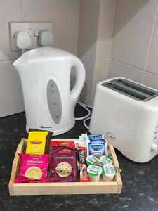 a cutting board with food next to a toaster at Cosy, modern Apartment in Darlaston