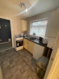 a small kitchen with a stove and a microwave at Cosy, modern Apartment in Darlaston