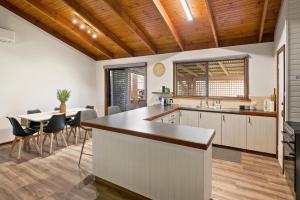 una cucina e una sala da pranzo con tavolo e sedie di Menta Cottage a Dunsborough