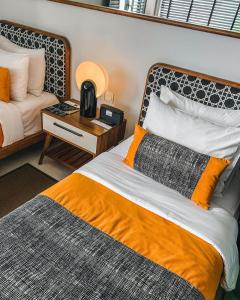 a bedroom with a bed with an orange blanket at Kosenda Hotel in Jakarta