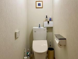 Elle comprend une petite salle de bains pourvue de toilettes blanches. dans l'établissement 八ヶ岳 HOKUTO BASE -Yatsugatake-, à Hokuto