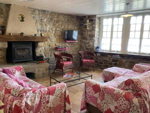 a living room with couches and a stone fireplace at Maison Étel, 3 pièces, 4 personnes - FR-1-397-6 in Étel