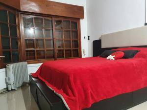 a bedroom with a bed with a red blanket at Uriburu B&B in Resistencia