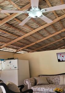 een woonkamer met een plafondventilator en een koelkast bij La Casita de Mary in Santa Cruz de Barahona