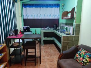 a living room with a table and a kitchen at Apartamento Sol Azul a 3 min del Aeropuerto SJO in Alajuela City